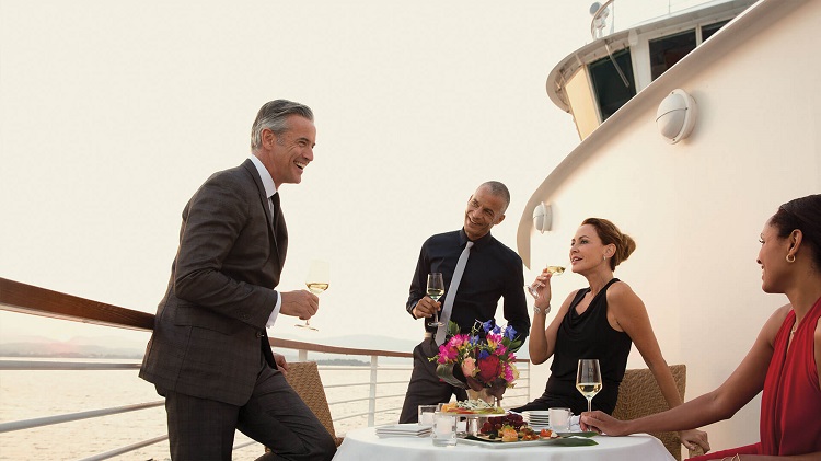 Friends drinking wine on their balcony on a Seabourn cruise