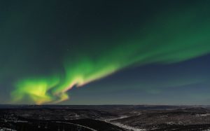 Green Northern Lights dancing over the snow in Fairbanks in Alaska